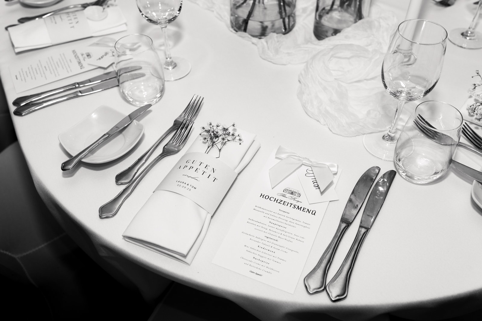 Elegant wedding table with menu cards, crystal glasses and silver cutlery photographed from above