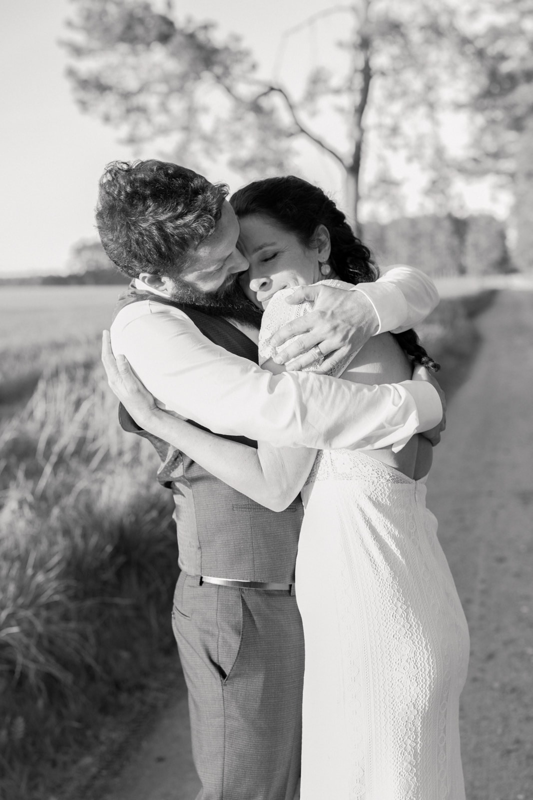 Wedding couple in emotional embrace in field during wedding