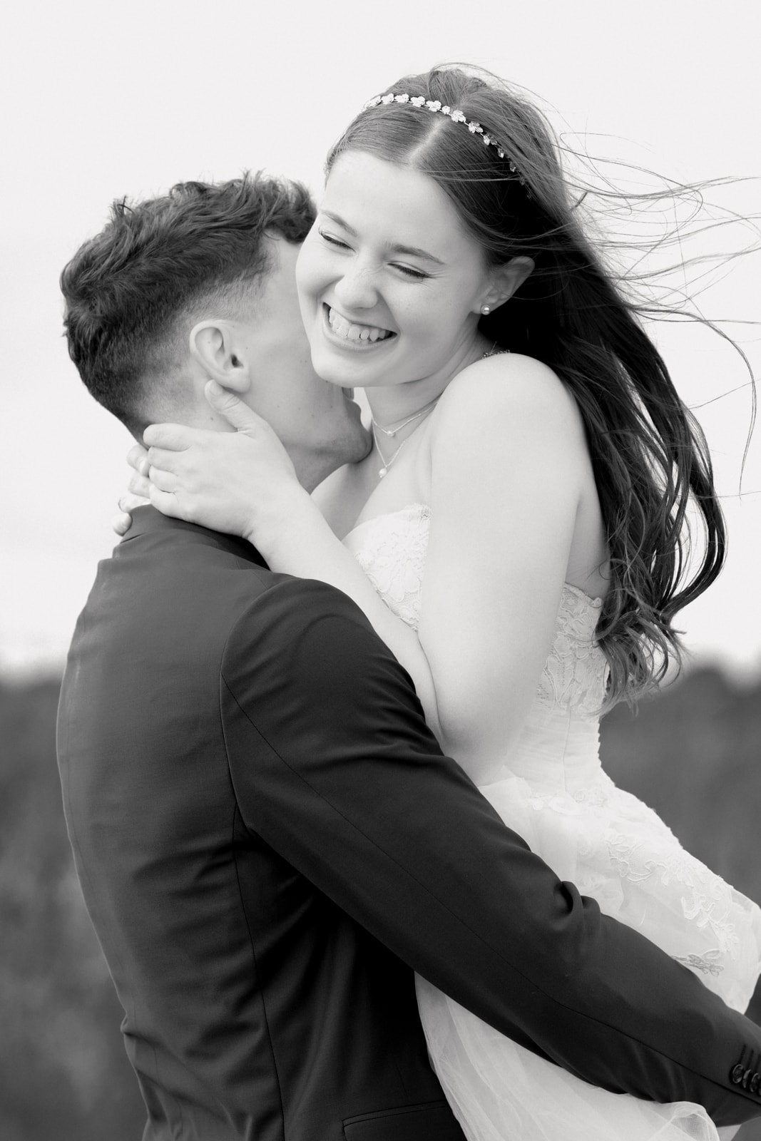 Radiant wedding couple in embrace during outdoor wedding