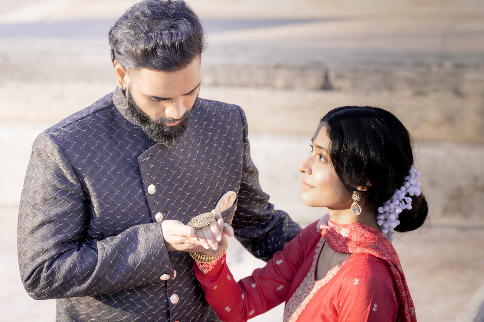 Indian groom presenting jewelry to his bride during ceremony